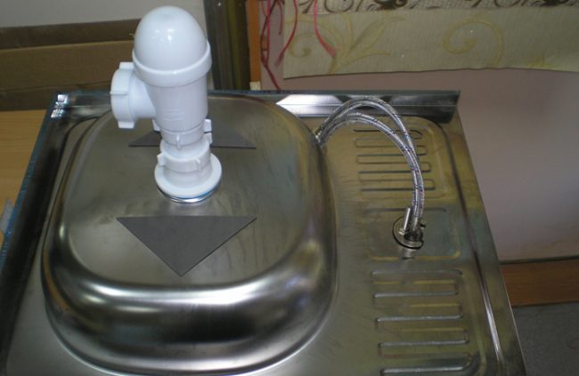 Бутылочный сифон закрепленный на кухонную мойку